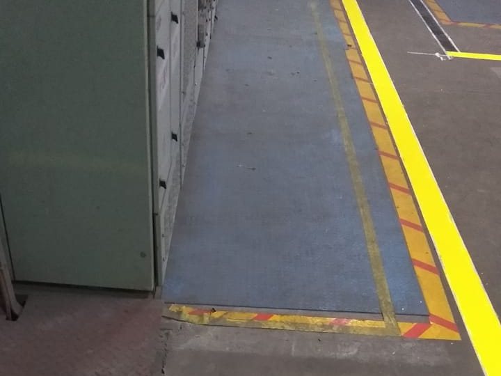 Yellow and red approach boundary floor marking along a switchgear lineup