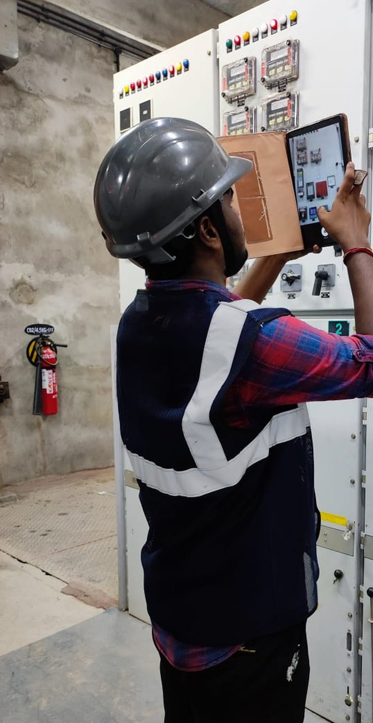 VB engineer capturing switchgear nameplate and settings data on a tablet, cubicle by cubicle, during an arc flash study walkdown