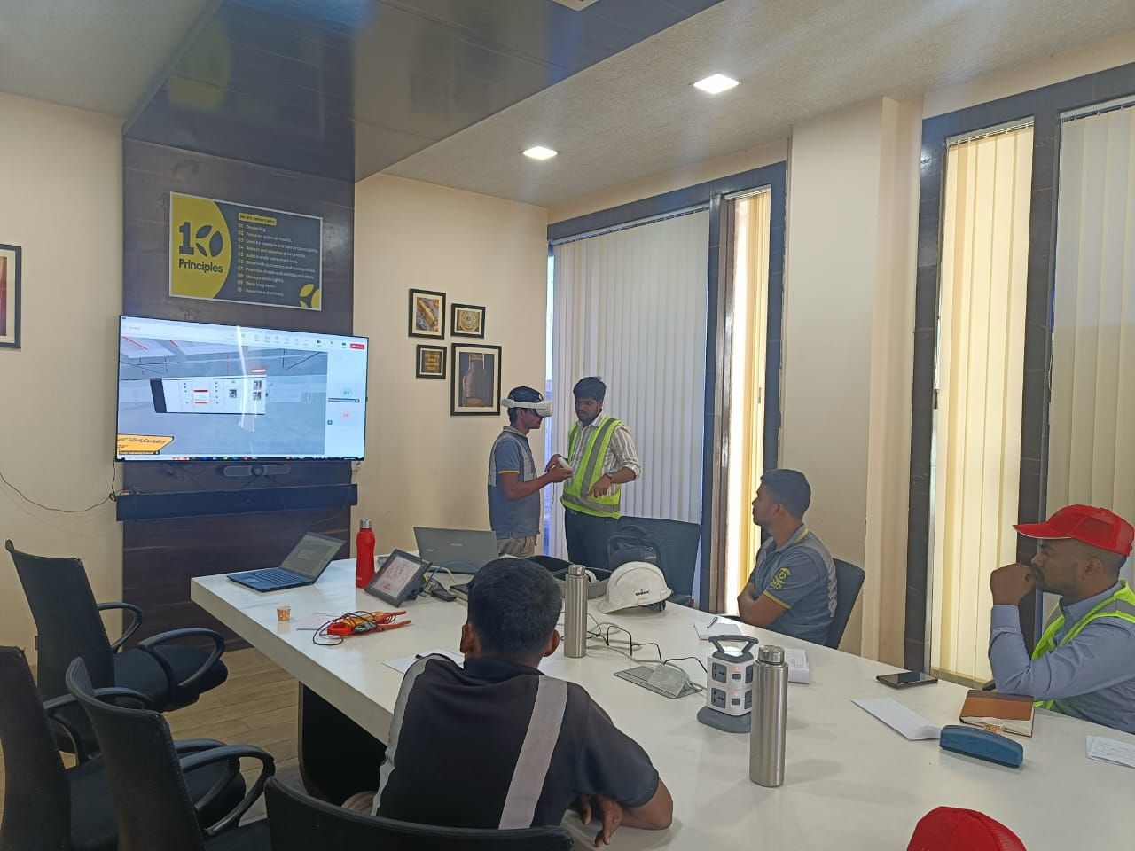 A Drona VR training session at VB, with a participant in a headset and the trainer view on screen