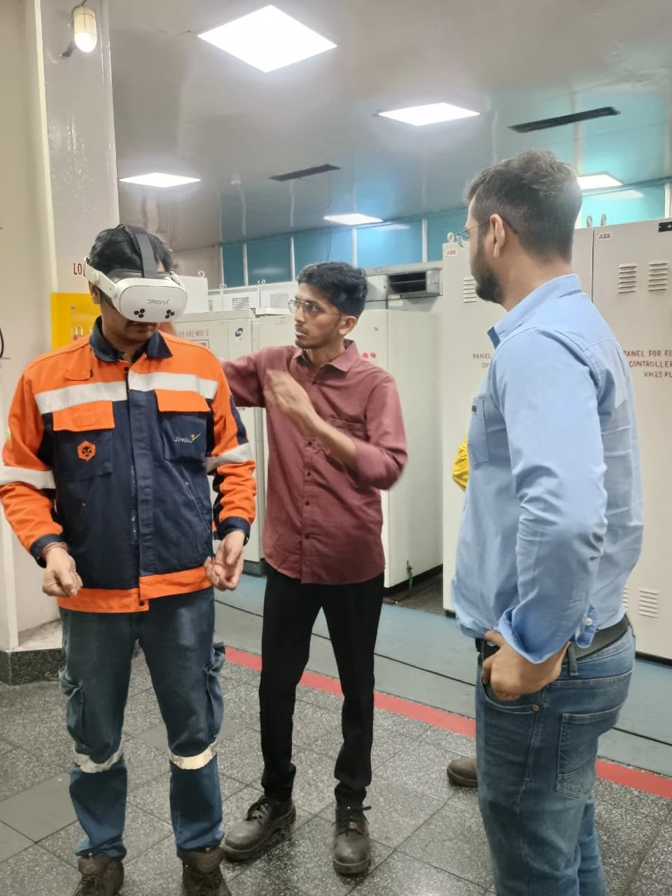 Industrial worker in orange overalls wearing Pico VR headset during VB Arc360 immersive arc flash safety training with VB instructor