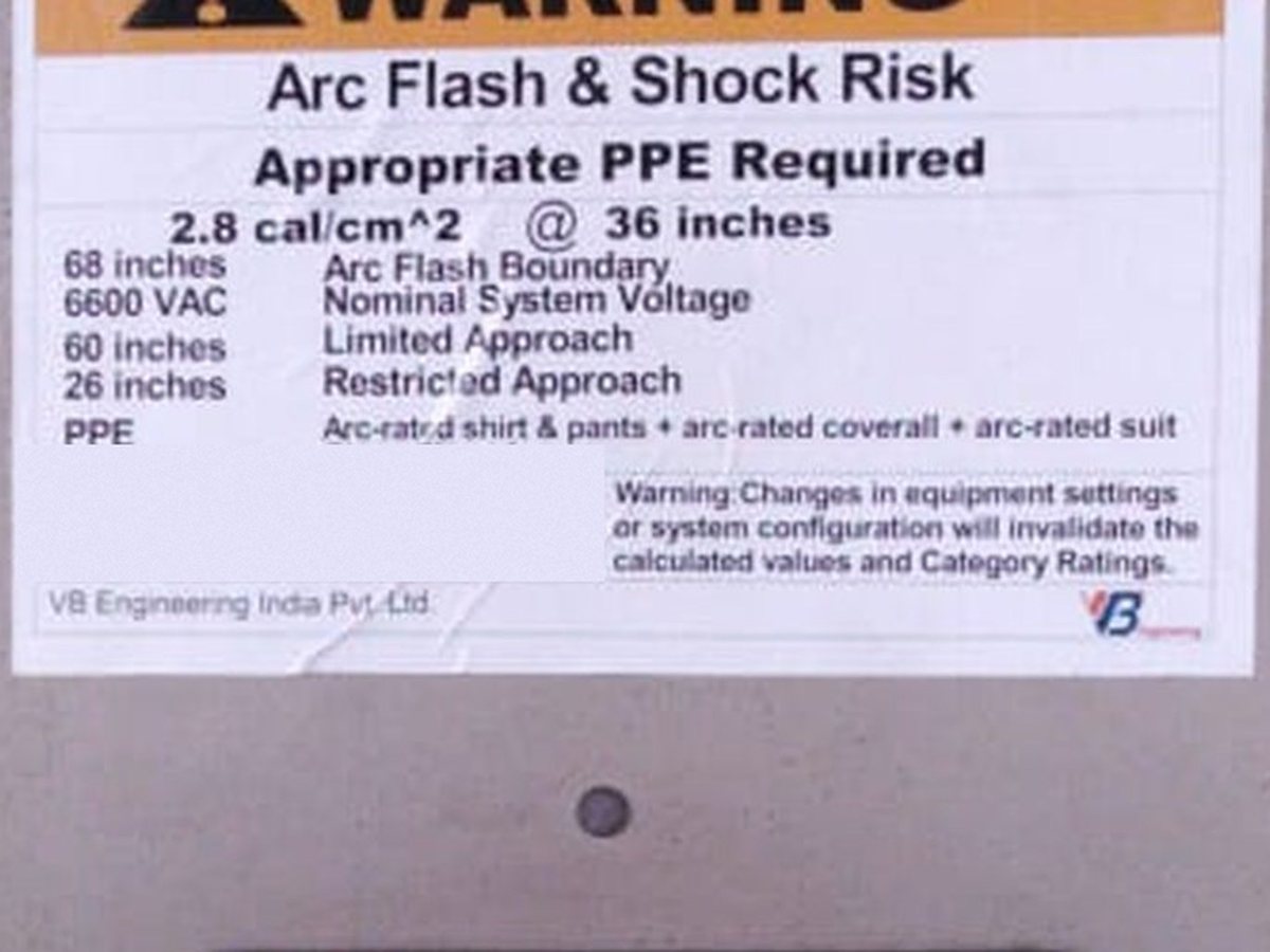 An arc flash and shock risk label installed on the switchboard door it describes, showing 2.8 cal/cm² at 36 inches, the arc flash boundary, the limited and restricted approach boundaries and the required PPE.